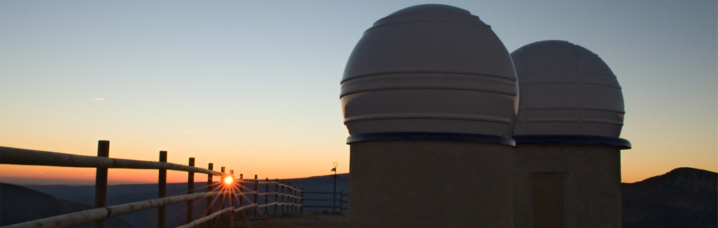 Photographie de 2 coupoles d'observatoire au soleil couchant